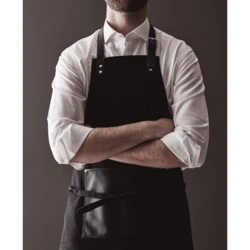 Stylish and classic apron in thick cotton canvas with discreet details in vegan leather. Adjustable buckle closure at the top and large pocket in the front. An apron with a long lifespan that only gets more beautiful with time. (VG019-03)-3
